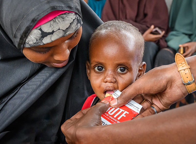 Un enfant mal nourri reçoit des aliments thérapeutiques.